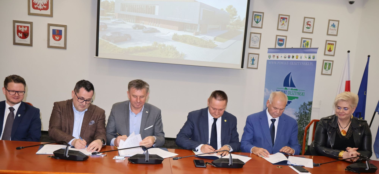 Podpisanie umowy pomiędzy Powiatem Olsztyńskim a spółką Rembud Na zdjęciu od lewej: Robert Waraksa, burmistrz Olsztynka, Grzegorz Dęby, wiceprezes zarządu Rembud Sp. z o.o., Robert Fronczek, prezes Rembudu, Andrzej Abako, starosta olsztyński, Artur Wrochna, członek zarządu Powiatu, Joanna Michalska-Reda, wicestarosta olsztyński 